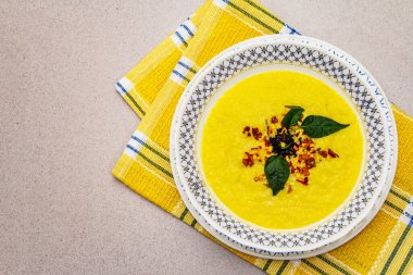 Taze sebzeli, otlu ve baharatlı mısır kremalı çorba. Klasik sonbahar yemeği, taş beton arka plan, üst görünüm.