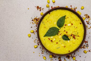 Taze sebzeli, otlu ve baharatlı mısır kremalı çorba. Klasik sonbahar yemeği, taş beton arka plan, üst görünüm.