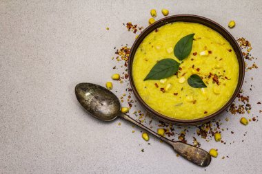 Taze sebzeli, otlu ve baharatlı mısır kremalı çorba. Klasik sonbahar yemeği, taş beton arka plan, üst görünüm.