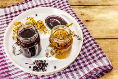 Mürver çayı, kurumuş çiçekler, olgun böğürtlen. Tatlı reçel, şurup ya da konfeksiyon. Sağlıklı tatlı, sıcak içecek. Alternatif tıp ve yaşam tarzı. Eski tahta masa, boşluğu kopyala