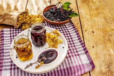 Mürver çayı, kurumuş çiçekler, olgun böğürtlen. Tatlı reçel, şurup ya da konfeksiyon. Sağlıklı tatlı, sıcak içecek. Alternatif tıp ve yaşam tarzı. Eski tahta masa, boşluğu kopyala