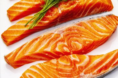 Çiğ Norveç alabalığı. Bir parça taze balık, limon, dereotu, acı biber, tuz. Suşi kalitesi, siyah taş beton arka plan