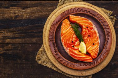 Çiğ Norveç alabalığı. Taze balık parçaları, limon, dereotu, biber, tuz. Eski tahta arka plan