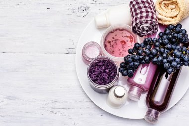 Olgun üzümlü doğal spa aksesuarları. Sağlıklı ve güzel kişisel bakım için taze malzemeler. Beyaz tahta tahta arka plan, üst görünüm