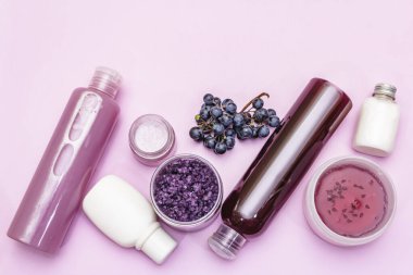 Olgun üzümlü doğal spa aksesuarları. Sağlıklı ve güzel kişisel bakım için taze malzemeler. Pembe arkaplan, üst görünüm