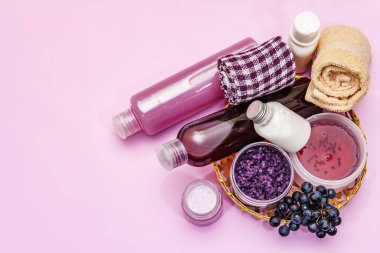 Olgun üzümlü doğal spa aksesuarları. Sağlıklı ve güzel kişisel bakım için taze malzemeler. Pembe arkaplan, üst görünüm