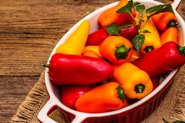 Çok renkli çeşitli bebek biberler: kırmızı, turuncu ve sarı. Taze hasat, sağlıklı yaşam tarzı için sulu ürünler. Eski tahta arka plan, kapat