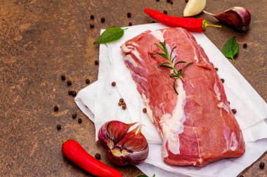 Çiğ dana eti. Olgun sebzeler ve mis kokulu baharatlarla taze parça. Taş beton arka plan, kapat