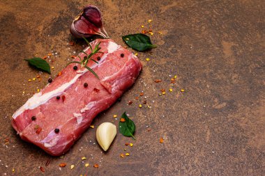 Çiğ dana eti. Olgun sebzeler ve mis kokulu baharatlarla taze parça. Taş beton arkaplan, kopyalama alanı
