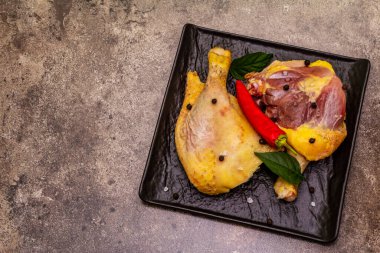 Çiğ çiğ organik tavuk bacağı. Sebze ve baharatlı taze et. Taş beton zemin, üst görünüm