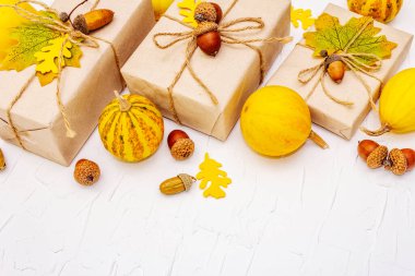 Sıfır atık hediye konsepti, plastik yaşam tarzı yok. Karton kutular, mini balkabakları, meşe palamutları ve dökülen yapraklarla yaratıcı bir sonbahar dekoru. Beyaz macun arkaplanı üzerine Şükran Günü veya Cadılar Bayramı konsepti, kopyalama alanı