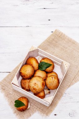 Kahverengi kraliyet şampiyonu mantarları el yapımı ahşap sandıkta. Geleneksel yemek tarifleri için işlenmemiş malzeme. Beyaz tahta tahta arka plan, üst görünüm