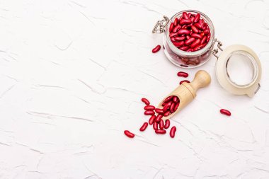 Kuru fasulye ya da cam kavanozda böbrek fasulyesi. Sağlıklı bir vegan diyeti için değerli bir protein kaynağı. Beyaz macun arkaplan, üst görünüm