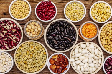 Çeşitli fasulye çeşitleri. Çeşitli kuru baklagiller, sağlıklı bir yaşam tarzı için vazgeçilmez proteinler. Eski tahta kaplama arka plan