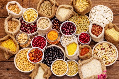 Değişik fasulye ve tahıl çeşitleri. Sağlıklı bir yaşam tarzı için vazgeçilmez protein kaynakları. Eski ahşap masa