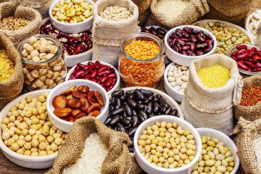 Değişik fasulye ve tahıl çeşitleri. Sağlıklı bir yaşam tarzı için vazgeçilmez protein kaynakları. Eski ahşap masa