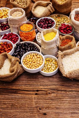Değişik fasulye ve tahıl çeşitleri. Sağlıklı bir yaşam tarzı için vazgeçilmez protein kaynakları. Eski ahşap masa