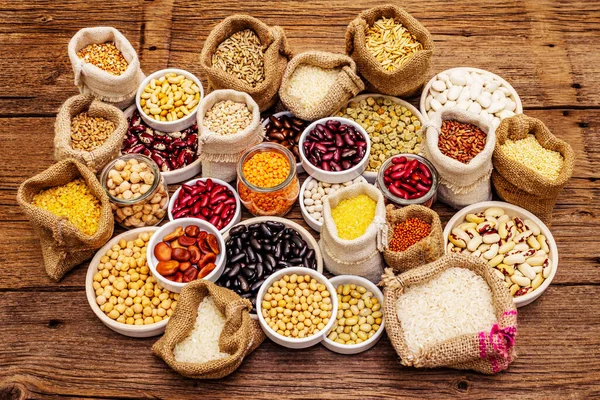 Değişik fasulye ve tahıl çeşitleri. Sağlıklı bir yaşam tarzı için vazgeçilmez protein kaynakları. Eski ahşap masa