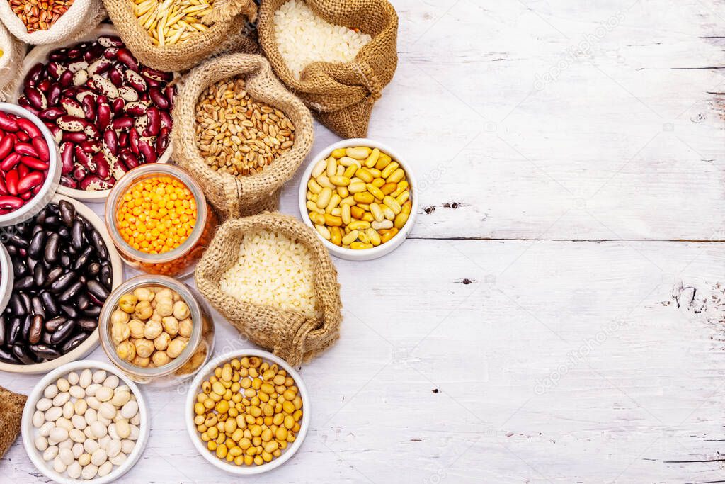 Assorted different types of beans and cereals grains. Set of indispensable sources of protein for a healthy lifestyle. White wooden boards background