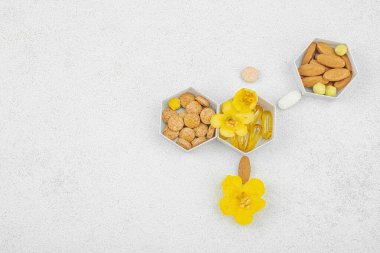 Kapsüllerle, tabletlerle ve taze Verbascum çiçekleriyle dolu altıgen kaplar aromalı kimyasal bir yapı oluşturmak için düzenlenmiştir.