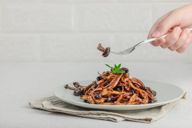 Fırında Shimeji mantarı, baharat ve otlarla dolu bir tabakta. El çatal, vejetaryen yaşam tarzı konsepti, hafif doğal arka plan, düz alan, kopyalama alanı