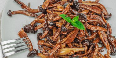 Fırında Shimeji mantarı, baharat ve otlarla dolu bir tabakta. Vegan yaşam tarzı konsepti, hafif doğal arkaplan, düz döşeme, afiş biçimi