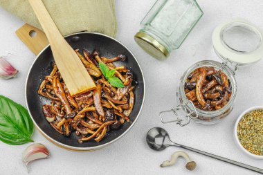 Kahverengi bir tabakta iki sosla servis edilen soslu Shimeji mantarı gurmesi. Sağlıklı bitki temelli yemek, modern mutfak yaşam tarzı, sıcak beton arka plan, üst görünüm.