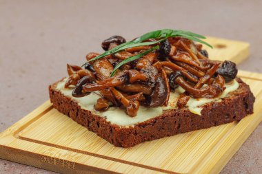 Kahverengi bir tabakta iki sosla servis edilen soslu Shimeji mantarı gurmesi. Sağlıklı bitki temelli yemek, modern mutfak yaşam tarzı, sıcak beton arka plan, üst görünüm.