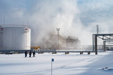 Kar bir petrol rafinerisinde arasında üç işçi yürümek