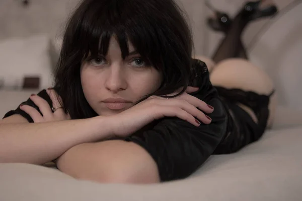 Látszó részére egy erotikus lőni a kamerába ágyban fekszik aranyos fiatal modell, szexi fehérnemű — Stock Fotó