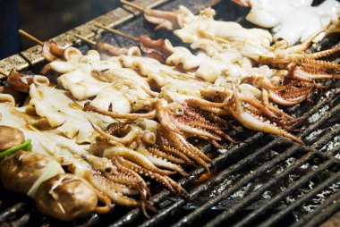 Birçok ızgara kalamar şiş ızgara gece piyasada yığını.