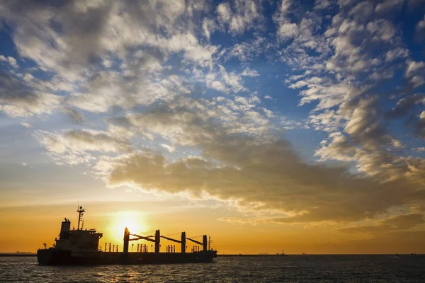 sunset into the sea with the Container ship Silhouette