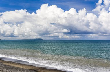 Mavi gökyüzü ve bulutların altındaki tropikal deniz