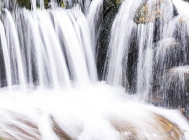 Şelalenin altındaki taşlar, arka plan olarak şelalenin yakınındaki taşlar..