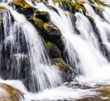 Şelalenin altındaki taşlar, arka plan olarak şelalenin yakınındaki taşlar..
