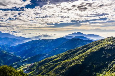 Nantou, Tayvan 'daki Hehuanshan Orman Dinlenme Bölgesi' nde muhteşem katmanlı dağların ve renkli bulutların günbatımı manzarası.