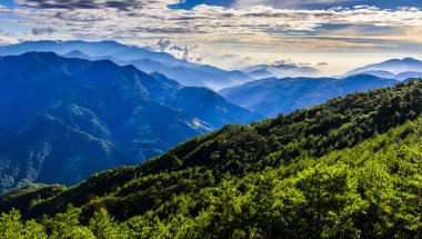 Gün batımında muhteşem dağların katmanları ve renkli bulutlar.
