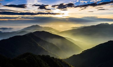 Gün batımında muhteşem dağların katmanları ve renkli bulutlar.