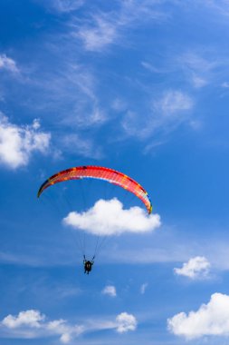Ekstrem Spor 'u mavi gökyüzü ve arka planda bulutlarla paraglitlemek, Sağlıklı Yaşam Tarzı ve Özgürlük kavramını birleştirmek
