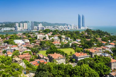 Gulangyu Adası 'nın havadan görünüşü ve Xiamen, Çin kıyıları boyunca uzanan modern binalar..