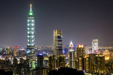 Taipei 101 gökdeleni ve Taipei Tayvan 'daki Xiangshan dağının tepesinden diğer modern binaların gece görüşü. 