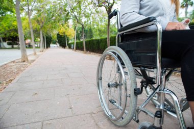 Tekerlekli sandalye dışarıda, tuğla zeminde bir parkta