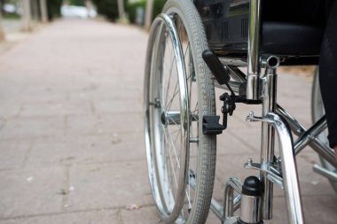 Tekerlekli sandalye dışarıda, tuğla zeminde bir parkta