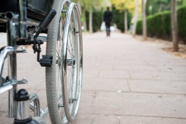 Tekerlekli sandalye dışarıda, tuğla zeminde bir parkta