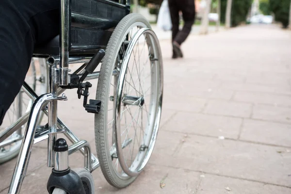 Tekerlekli sandalye dışarıda, tuğla zeminde bir parkta