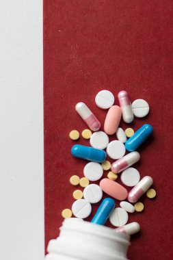 Beyaz pils ve kapsül kırmızı zemin üzerine closeup. tıbbi geçmişi
