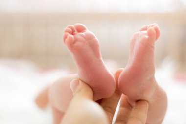 Bebek ayakları annenin ellerinde. Anne ve çocuğu. Mutlu aile kavramı. Anneliğin güzel kavramsal görüntüsü