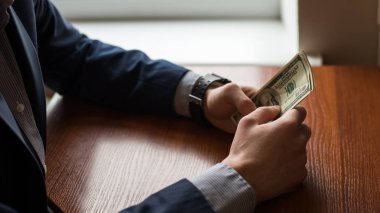Para, kapma işadamı el bize Doları (Usd) bills.man takım elbiseli. ahşap arka plan