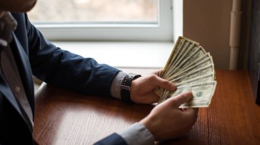 Para Holding iş elini. Avuç, dolar ahşap arka plan.