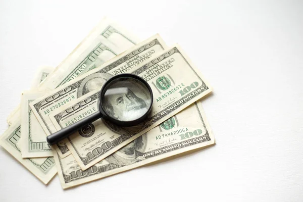 Lupa encontra-se em dólares americanos isolados em fundo branco — Fotografia de Stock